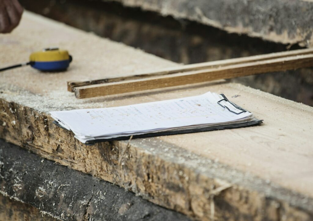 Craftsmanship in progress with clipboard and measurement tape laid out on timber.